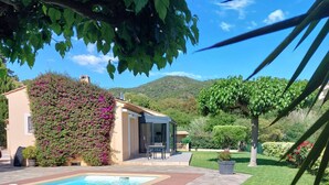 A poolside area with a stone deck, a covered seating area, and a view of a mountain in the background. - Villa for 6 people with pool, just steps from the Golf de Valcros, in La Londe-Les-Maures (LA LONDE LES MAURES)