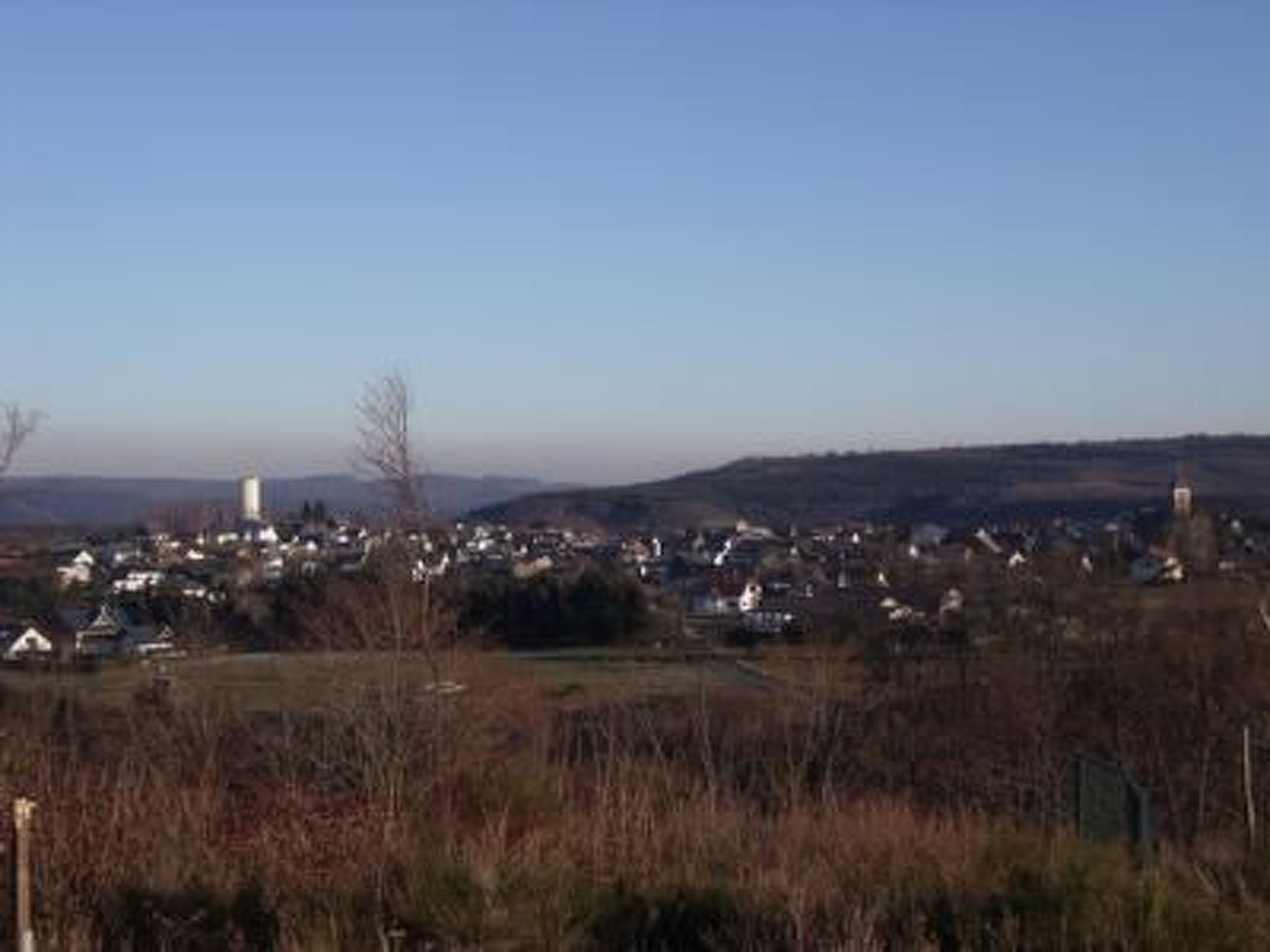 Paesaggio rurale con un villaggio, comprendente case, una chiesa e una torre dell'acqua.
