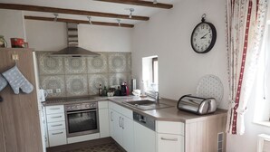 A compact kitchen with a stove, oven, sink, and a toaster. - Hochwertige Ferienwohnung mit Terrasse und Garten by Interhome (Zülpich)