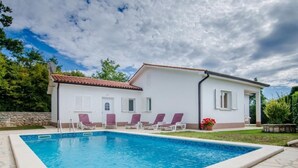 A poolside area with a swimming pool, white walls, and a tiled roof. - Haus Mia by Interhome (Labin)
