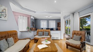 A spacious living area with a wooden dining table, leather sofas, and a kitchen in the background. - mit Blick auf das Wasser by Interhome (Labin)