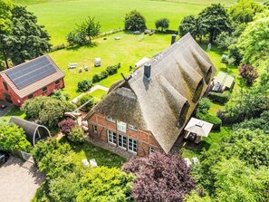 A large house with a thatched roof, surrounded by a well-maintained garden and a tennis court. - Reethaus Mertinat ''For Six'' mit Meerblick by Interhome (Gollwitz (Insel Poel))
