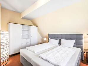 Ein Hotelzimmer mit einem Bett, einem Kleiderschrank und einem Schreibtisch.
