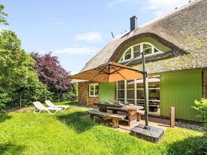 A thatched-roof house with a dining area, outdoor seating, and a garden. - Reethaus Mertinat ''For Six'' mit Meerblick by Interhome (Gollwitz (Insel Poel))