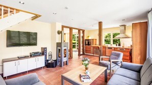 Ein modernes Wohnzimmer mit Kamin, Fernseher und Sofa.