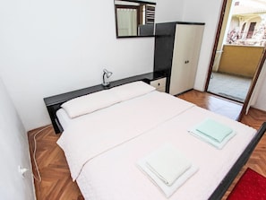 A bedroom with a bed, a desk, a mirror, and a wardrobe. - Ap Lora 3 by Interhome (Rovinj)