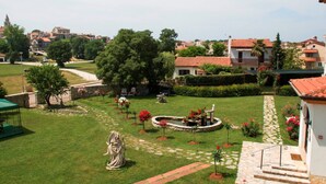 A well-maintained garden with a statue, a fountain, and a stone pathway leading to a building with a red-tiled roof. - Villa Liet 9. by Interhome (Poreč/Funtana)