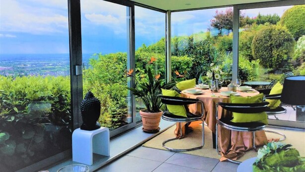 Et moderne spiseområde med panoramaudsigt over et frodigt landskab.
