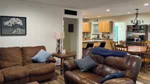 Ein Wohnzimmer mit braunen Ledersofas, einem Couchtisch und einem gerahmten Bild an der Wand.