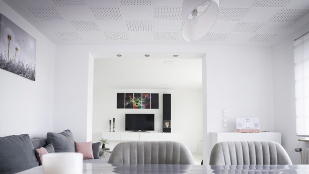 Un salon moderne avec un canapé gris, une table basse et un téléviseur.