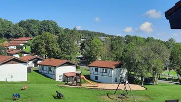 Ein Wohngebiet mit Häusern, einem Spielplatz und einer Wiese.