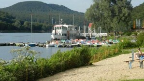 A boat docked at a marina with a sandy beach and greenery in the background. - Preiser in Schieder-Schwalenberg by Interhome (Schieder-Schwalenberg)