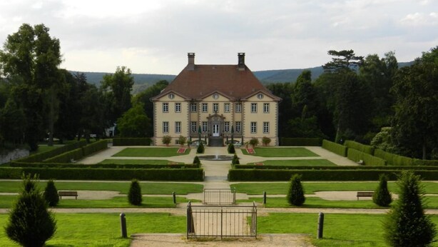 A large, symmetrical building with a central entrance, surrounded by well-manicured gardens and hedges. - Preiser in Schieder-Schwalenberg by Interhome (Schieder-Schwalenberg)