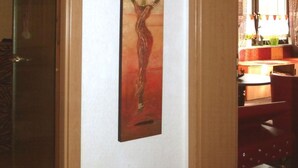 Un pasillo con una puerta de madera, una obra de arte enmarcada en la pared y una alfombra en el suelo.