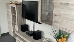 A modern living room with a built-in TV, wooden cabinetry, and decorative items. - in ruhiger Lage in Seenähe by Interhome (Oberteuringen)