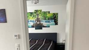 A modern bedroom with a bed, a nightstand, and a wall-mounted artwork. - in ruhiger Lage in Seenähe by Interhome (Oberteuringen)