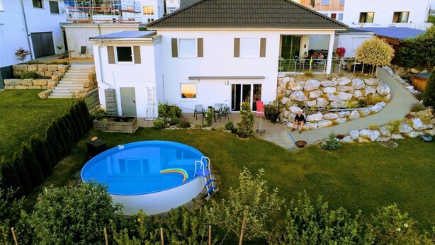 A two-story house with a swimming pool, stone landscaping, and a small garden. - Wohnung mit großer Gartenterrasse und Ausblick by Interhome (Argenbühl)