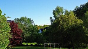 A grassy outdoor area with a swing set and trees. - Appartement in Unzenberg Hunsrück by Interhome (Dickenschied)