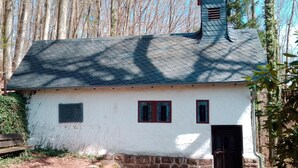 Il s’agit d’un petit bâtiment d’un seul étage, à l’extérieur blanc et au toit foncé. Il possède une petite fenêtre à cadre rouge, une porte et une cheminée.