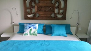 A bed with a white headboard, a blue bedspread, and three pillows in shades of blue. - in Zendscheid mit Offenem Kamin by Interhome (Zendscheid)