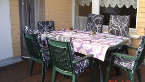 A wooden deck with a table and chairs, lace curtains, and a date stamp. - Santa Maria by Interhome (Nettersheim)