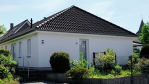 A single-story house with a tiled roof, a small front porch, and a visible door. - Schönes Ferienhaus in Brochterbeck mit Garten by Interhome (Tecklenburg)