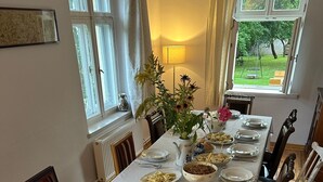A dining table set with plates, bowls, and utensils, surrounded by striped chairs.