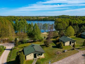 Propiedad junto al lago con dos cabañas, un camino de tierra y vistas al lago.