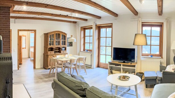 Una sala de estar con sofá, mesa de comedor, televisor y chimenea.