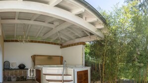 Ein Wellnessbereich mit Whirlpool, Holztreppen und einem Kamin aus Stein.