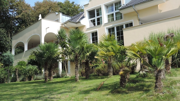 Ein großes, zweistöckiges Gebäude mit heller Fassade, zahlreichen Fenstern und einem Flachdach.