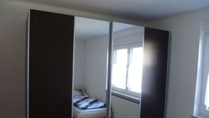 Een slaapkamer met een bed, een raam en een radiator.