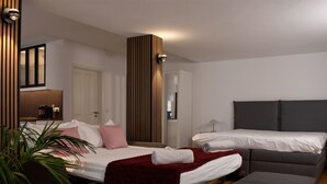 Quarto de hotel moderno com cama, sofá, escrivaninha e planta em vaso.