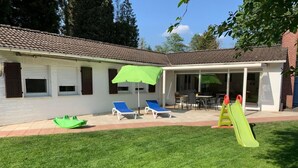 A house with a patio area, a green lawn, and a play structure. - Natur pur am Veb´nekoten by Interhome (Niederkrüchten)