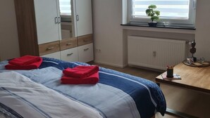 A bedroom with a bed, a wardrobe, a desk with a plant, and a window with blinds. - Zentrale, liebevoll eingerichtete Ferienwohnung by Interhome (Monheim)