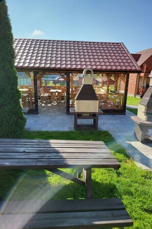Un'area relax all'aperto con panche in legno e un barbecue.