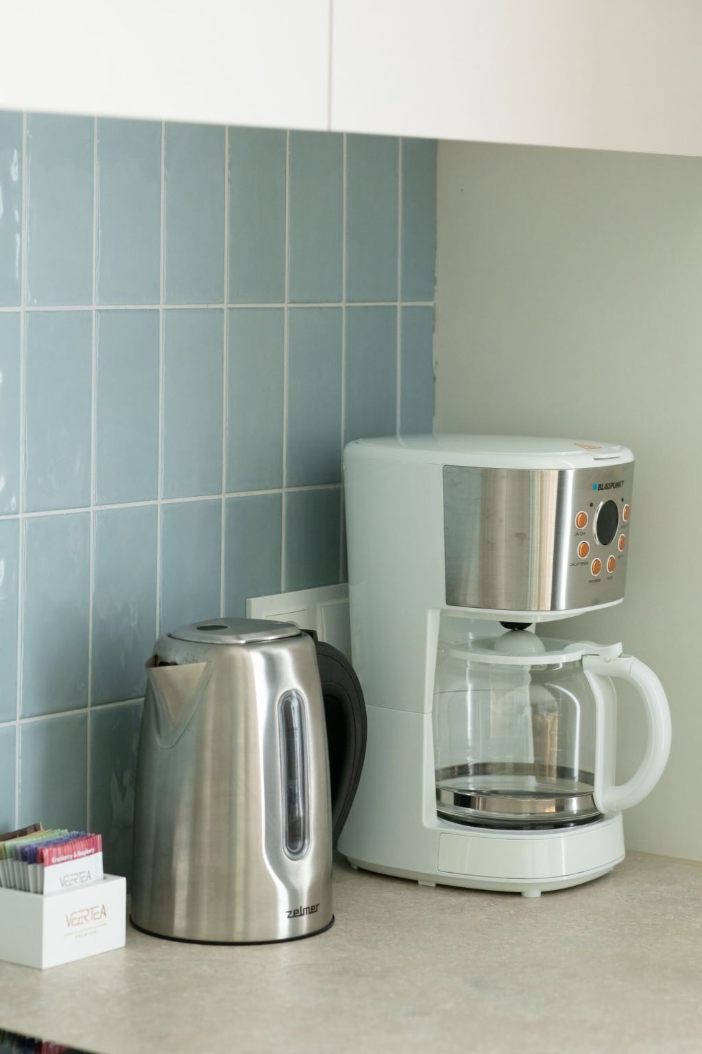 Een koffiezetapparaat en een waterkoker op een aanrecht.