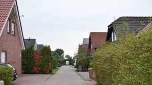 Un carrer residencial amb cases, un camí pavimentat i vegetació.