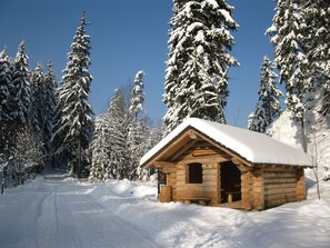 Eine Holzhütte mit schneebedecktem Dach und einem Schild mit der Aufschrift 'Tunglertensprund'.