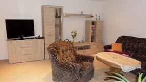 A living room with a sofa, a chair, a TV, and a cabinet. - Vacation home Silvia by Interhome (Altwarp)