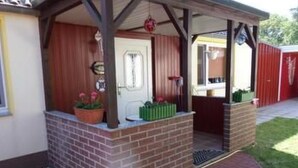 A brick-built structure with a covered porch, a door, and potted plants. - Vacation home Silvia by Interhome (Altwarp)