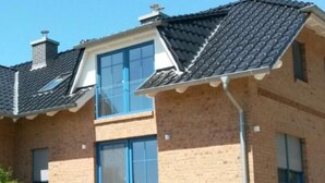 A two-story house with a brick facade, large windows, and a sloped roof. - Apartment Möwe by Interhome (Baabe)