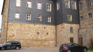 A multi-story building with a stone facade and red-tiled roof.
