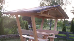 A wooden picnic shelter with benches.