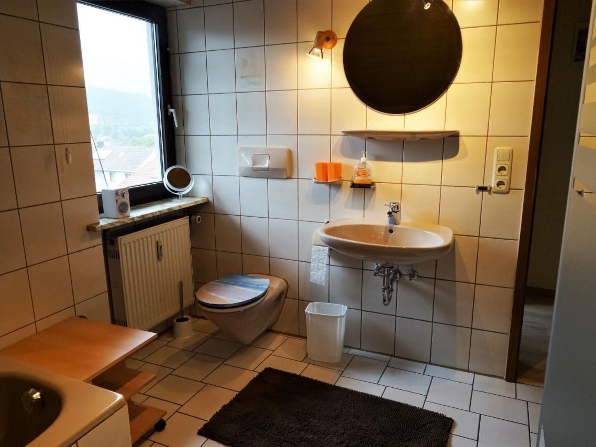 A compact bathroom with a toilet, sink, and a small window.