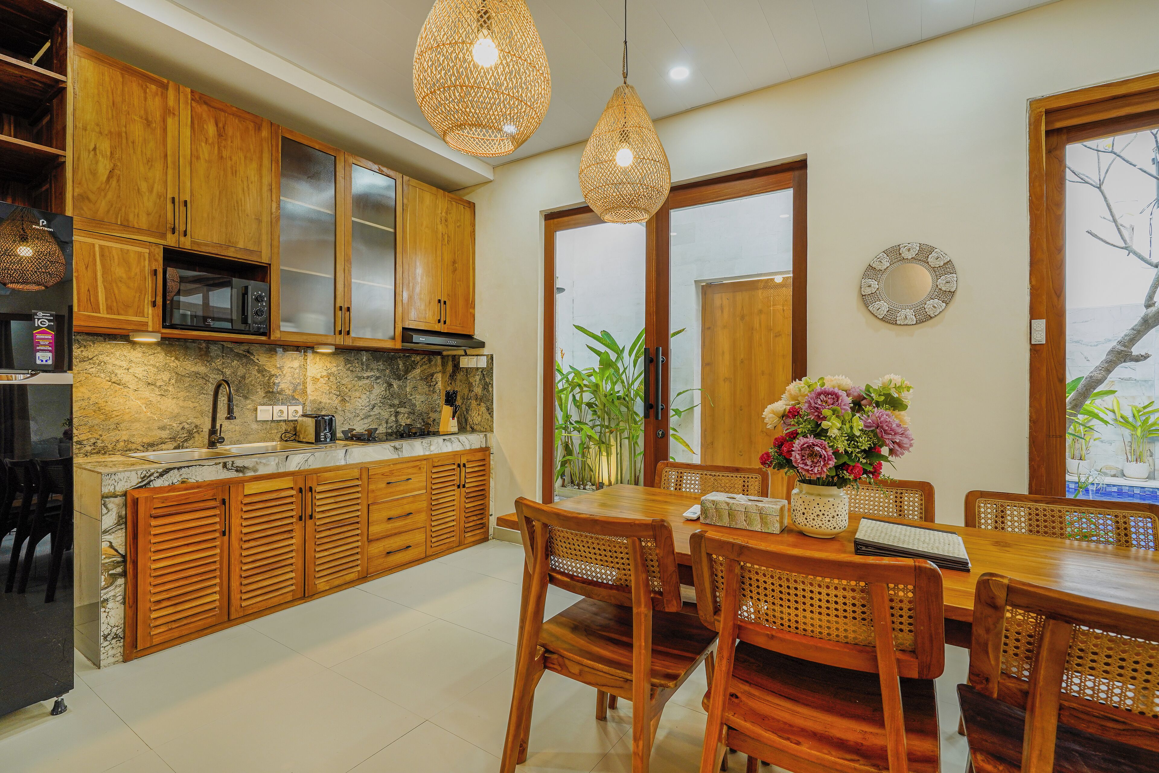 A modern kitchen with wooden cabinets, a granite countertop, and a dining area with a wooden table and chairs.