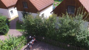A residential area with two houses, a paved driveway, and a parked motorcycle. - Haus im Grünen by Interhome (Marktgraitz)