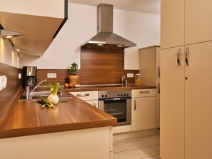 A modern kitchen with a wooden countertop, stainless steel appliances, and a built-in oven. - am Johannesbühl by Interhome (Geigant)