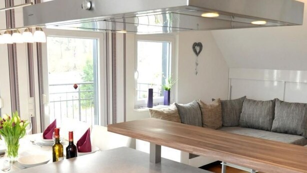 A modern kitchen with a central island, built-in appliances, and a wooden ceiling. - in Feldmannshof mit Grill und Garten by Interhome (Drolshagen)