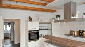 A modern kitchen with white cabinetry, a wooden countertop, and a built-in oven. - in Feldmannshof mit Grill und Garten by Interhome (Drolshagen)